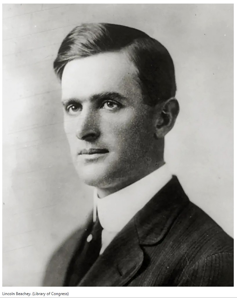 Black and white portrait of a man with dark hair, wearing a suit and a collared shirt, looking confidently towards the viewer.